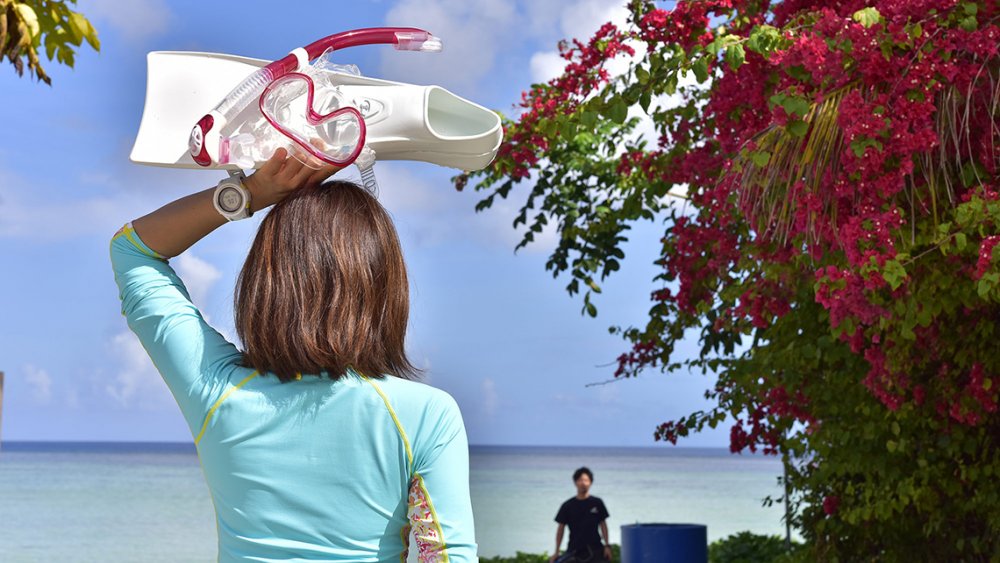 ダイビング器材を手に持つ女性